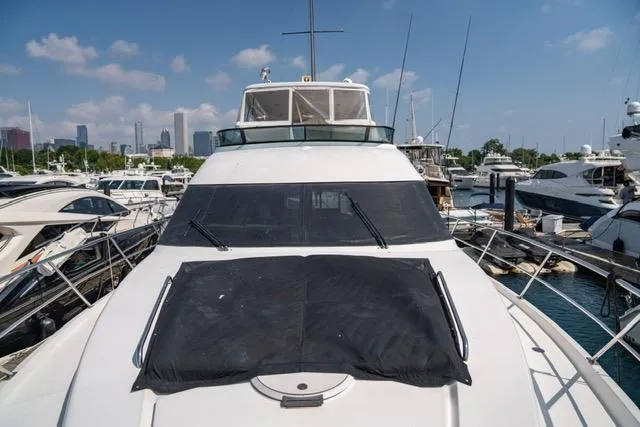 Slide: The Image of 2005 Neptunus 62 Flybridge yacht docked in marina under clear blue sky. - 25