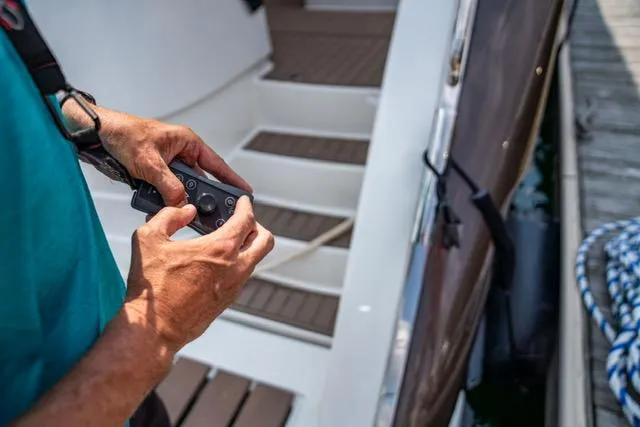 Slide: The Image of Person operating controls on 2005 Neptunus 62 Flybridge yacht deck. - 29