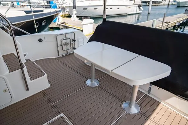 Slide: The Image of 2005 Neptunus 62 Flybridge yacht deck with table and seating area. - 4