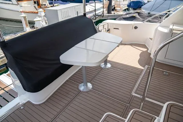 Slide: The Image of Neptunus 62 Flybridge 2005 yacht deck with seating and table, docked at marina. - 42