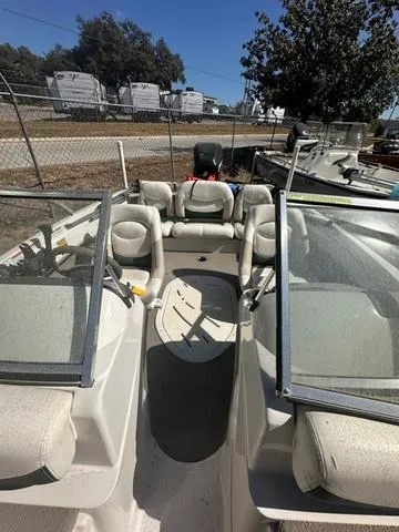 Slide: The Image of 2005 Sun Tracker 189 SPORT boat with seating and windshield, parked outdoors. - 5