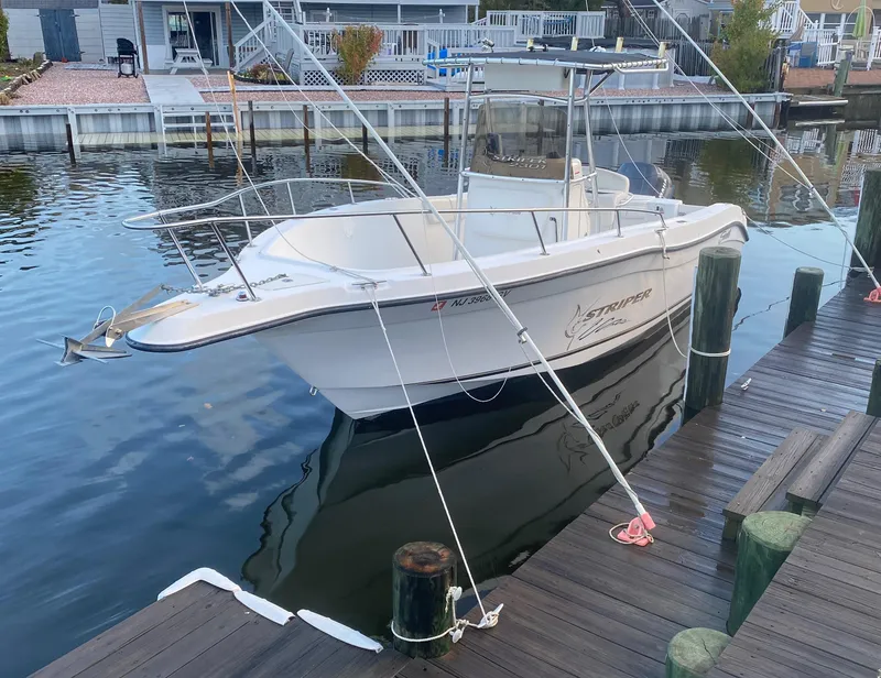 Slide: The Image of 2004 Seaswirl Striper 2301 Center Console boat docked on calm water. - 0