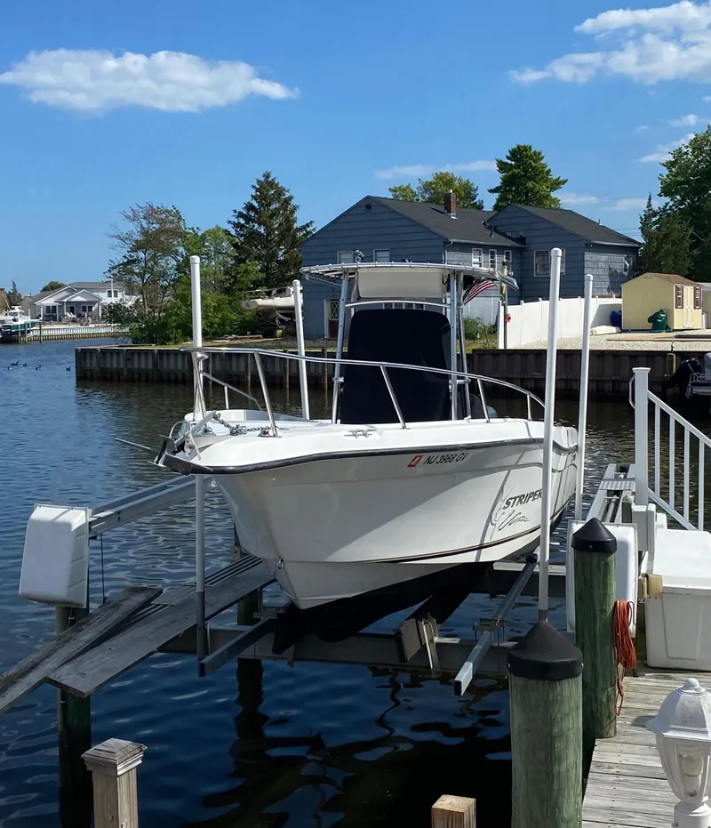 Slide: The Image of 2004 Seaswirl Striper 2301 Center Console boat docked by waterfront homes. - 1