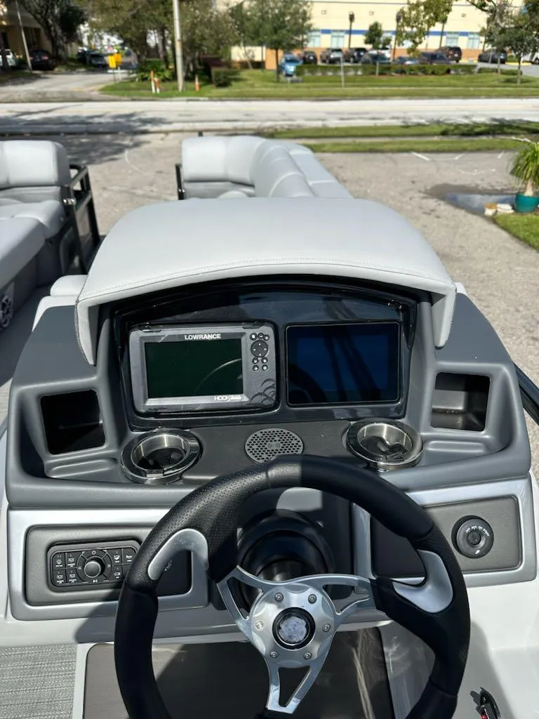Slide: The Image of 2024 Regency 250 DL3 boat dashboard with modern navigation system and steering wheel. - 5