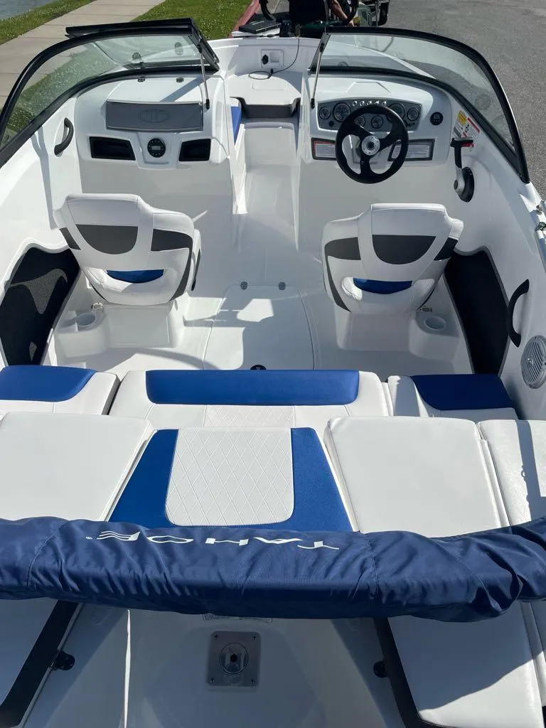 Slide: The Image of 2024 Tahoe 185 S boat interior with white and blue seating, steering wheel, and dashboard. - 4