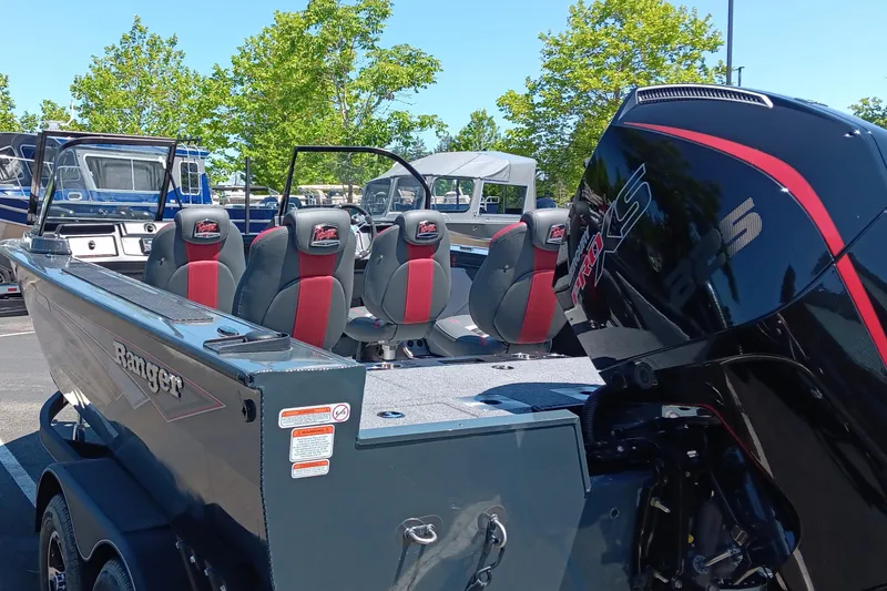 Slide: The Image of 2024 Ranger VX1988 WT boat with red and black seats, powerful outboard motor, parked outdoors. - 1