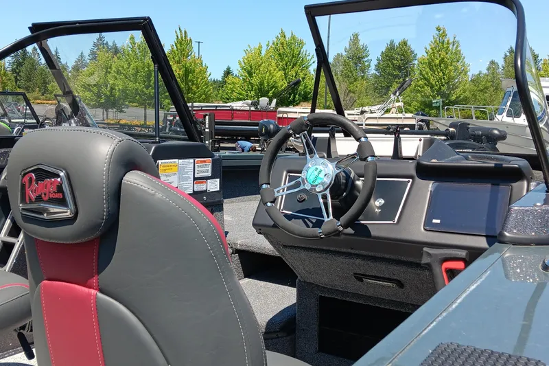 Slide: The Image of 2024 Ranger VX1988 WT boat interior with steering wheel and dashboard, featuring red and black seating. - 2