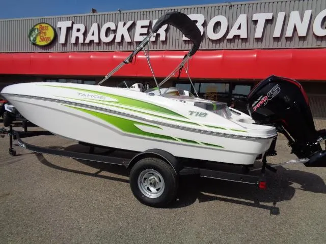 Slide: The Image of 2024 Tahoe T18 boat with green accents on trailer at Tracker Boating store. - 2