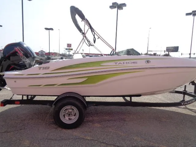 Slide: The Image of 2024 Tahoe T18 boat with green accents on a trailer in a parking lot. - 3