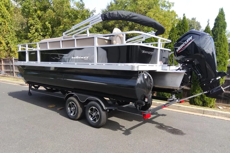 The Image of 2024 Ranger Reata 200F pontoon boat with Mercury outboard engine on a trailer. - 0