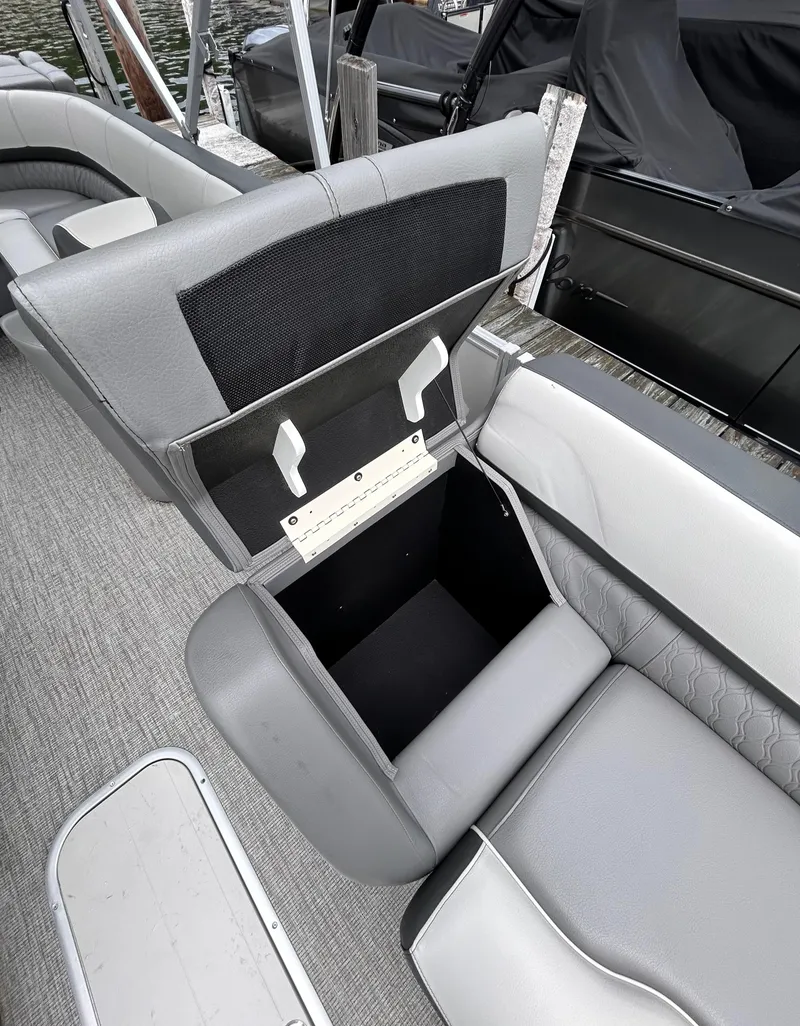 Slide: The Image of 2021 Avalon Catalina Cruise 25 boat with open storage compartment, gray seating, and carpeted floor. - 12