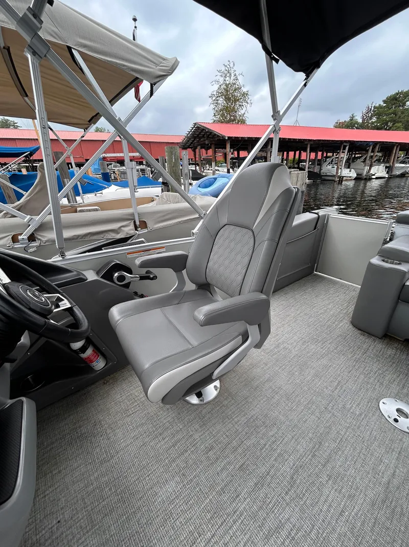Slide: The Image of 2021 Avalon Catalina Cruise 25 boat interior with gray captain's chair and marina backdrop. - 22