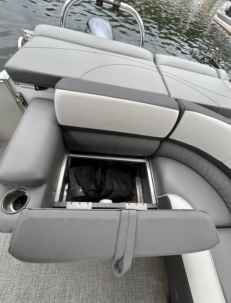Slide: The Image of 2021 Avalon Catalina Cruise 25 boat seating with storage compartment open. - 26