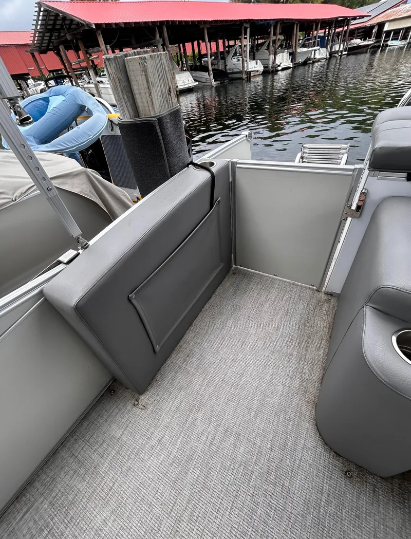 Slide: The Image of 2021 Avalon Catalina Cruise 25 boat interior with gray seating and dock view. - 31