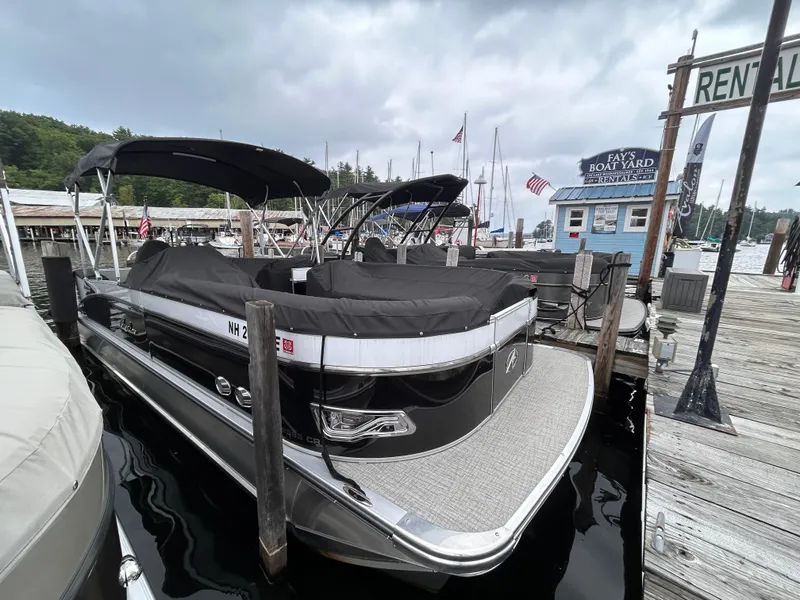 Slide: The Image of 2021 Avalon Catalina Cruise 25 pontoon boat docked at marina with rental sign. - 4