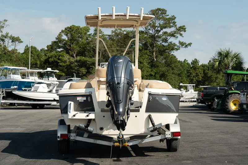 Slide: The Image of 2025 Scout 195 Sportfish boat on trailer, rear view, in a marina setting. - 10