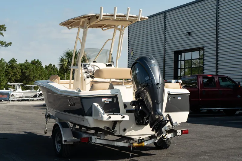 Slide: The Image of 2025 Scout 195 Sportfish boat on trailer, parked outdoors. - 11