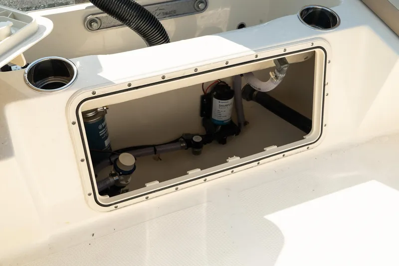 Slide: The Image of 2025 Scout 195 Sportfish boat interior compartment with visible wiring and components. - 15