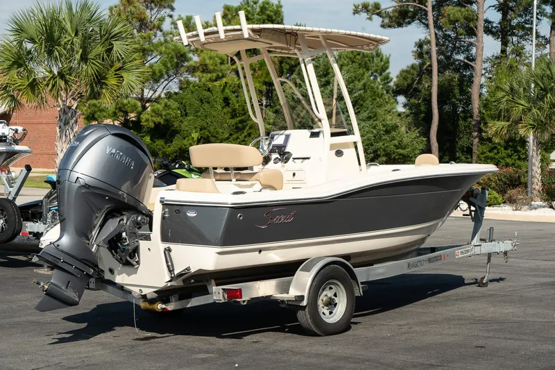 Slide: The Image of 2025 Scout 195 Sportfish boat on trailer, parked outdoors. - 9