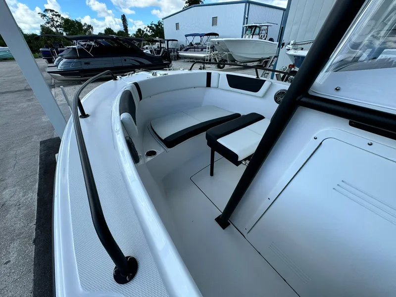 Slide: The Image of 2025 Edgewater 208 CC boat interior with seating, docked near other boats. - 13