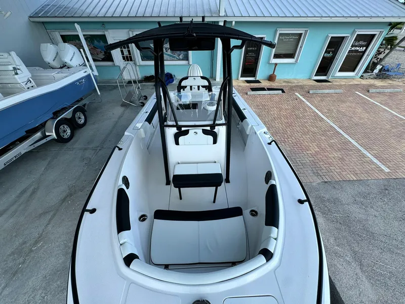 Slide: The Image of 2025 Edgewater 208 CC boat with sleek design, docked near a blue building. - 15