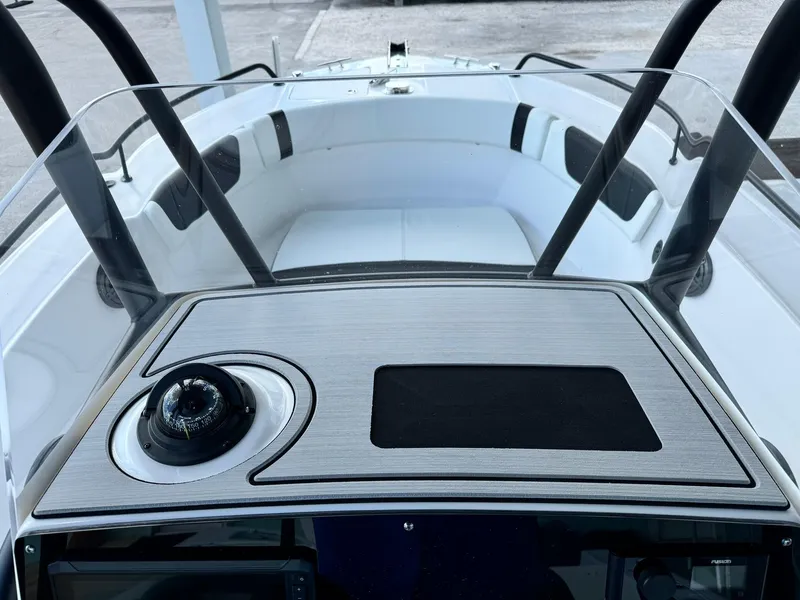 Slide: The Image of 2025 Edgewater 208 CC boat dashboard with compass and seating area. - 17