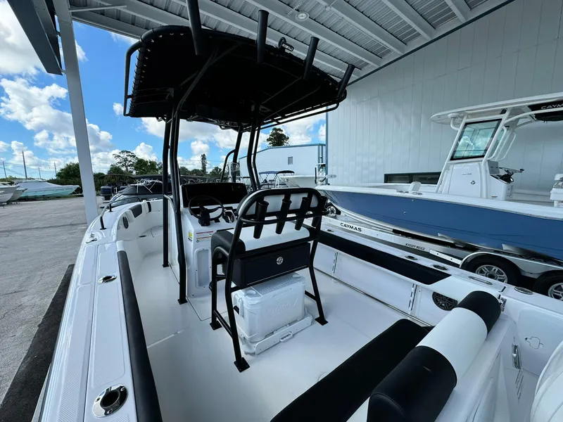 Slide: The Image of 2025 Edgewater 208 CC boat interior with seating and console under a covered dock. - 6