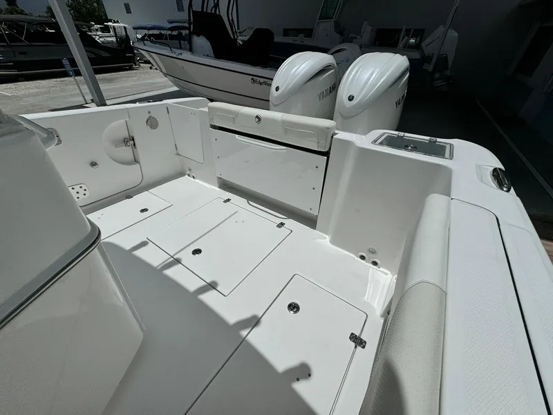 Slide: The Image of 2025 Edgewater 262 CC boat interior with dual engines, spacious deck, and seating area. - 10
