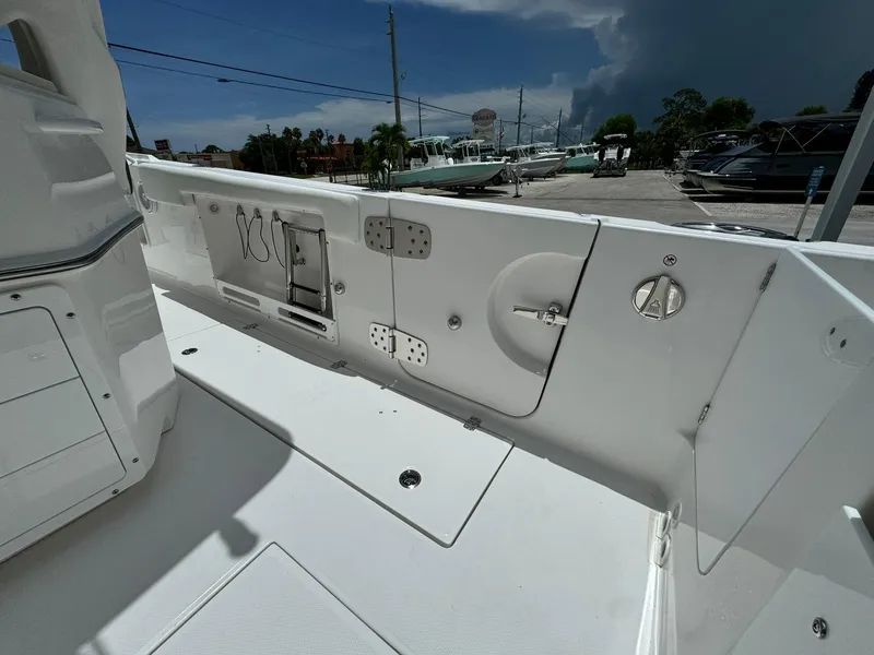 Slide: The Image of 2025 Edgewater 262 CC boat interior, featuring sleek white deck and storage compartments. - 12