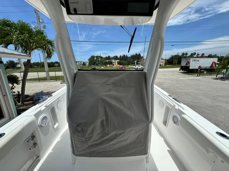Slide: The Image of 2025 Edgewater 262 CC boat interior with covered console, parked outdoors. - 15