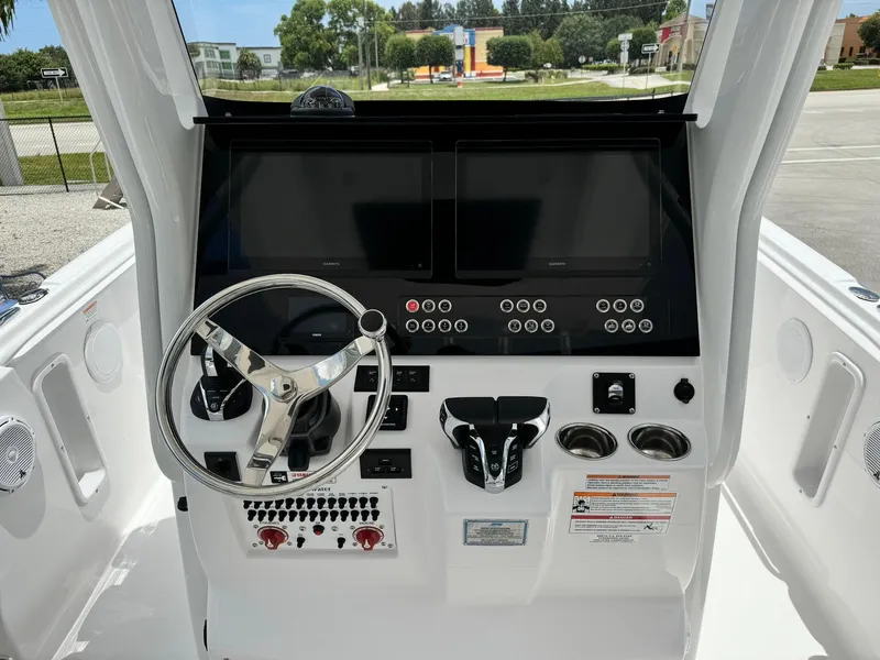 Slide: The Image of 2025 Edgewater 262 CC boat dashboard with steering wheel and control panel. - 17