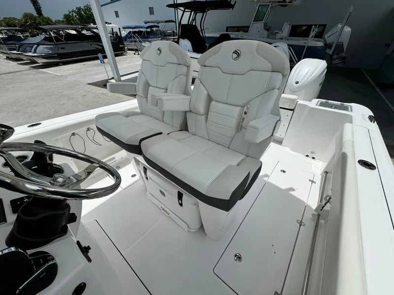 Slide: The Image of 2025 Edgewater 262 CC boat with luxurious white seating and modern steering console. - 18