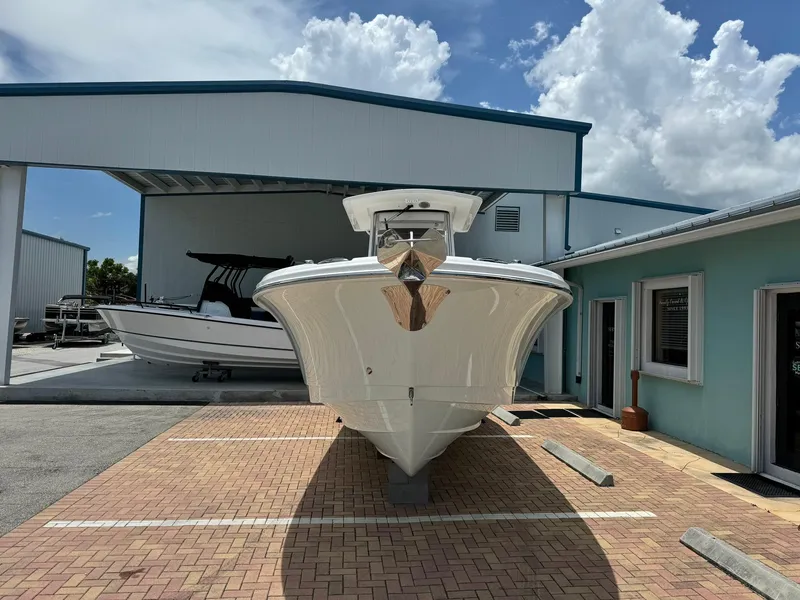 Slide: The Image of 2025 Edgewater 262 CC boat parked in marina under blue sky. - 2