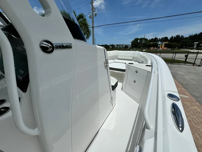 Slide: The Image of 2025 Edgewater 262 CC boat, sleek white design, spacious deck under clear blue sky. - 21