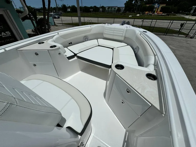 Slide: The Image of 2025 Edgewater 262 CC boat interior with white seating and storage compartments. - 22