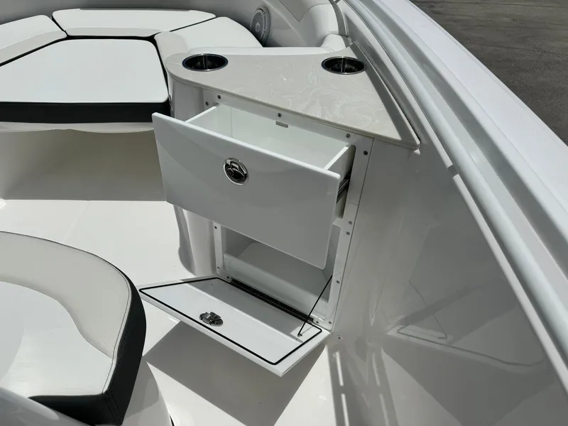 Slide: The Image of 2025 Edgewater 262 CC boat interior with storage drawer and cup holders. - 23