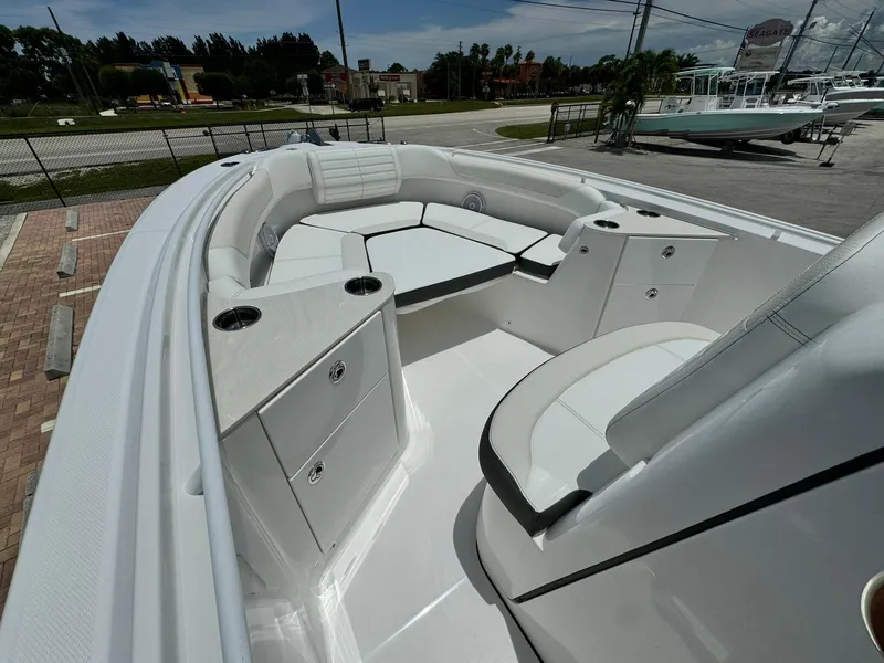 Slide: The Image of 2025 Edgewater 262 CC boat interior with white seating and storage compartments. - 24