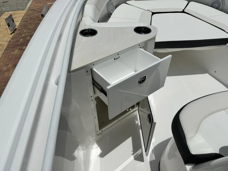 Slide: The Image of 2025 Edgewater 262 CC boat interior with open storage compartment and seating area. - 25