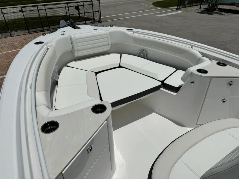 Slide: The Image of 2025 Edgewater 262 CC boat interior with white cushioned seating and cup holders. - 26