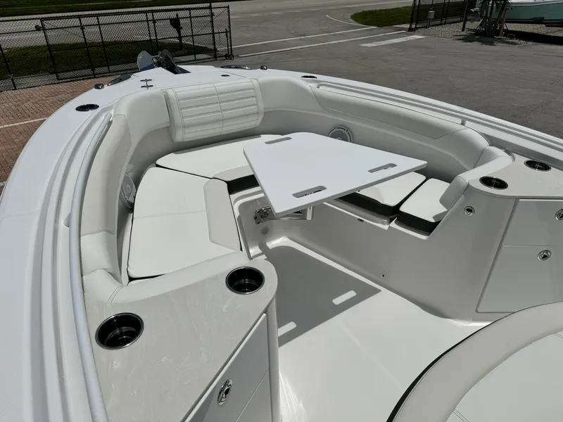 Slide: The Image of 2025 Edgewater 262 CC boat interior with white seating and table. - 27