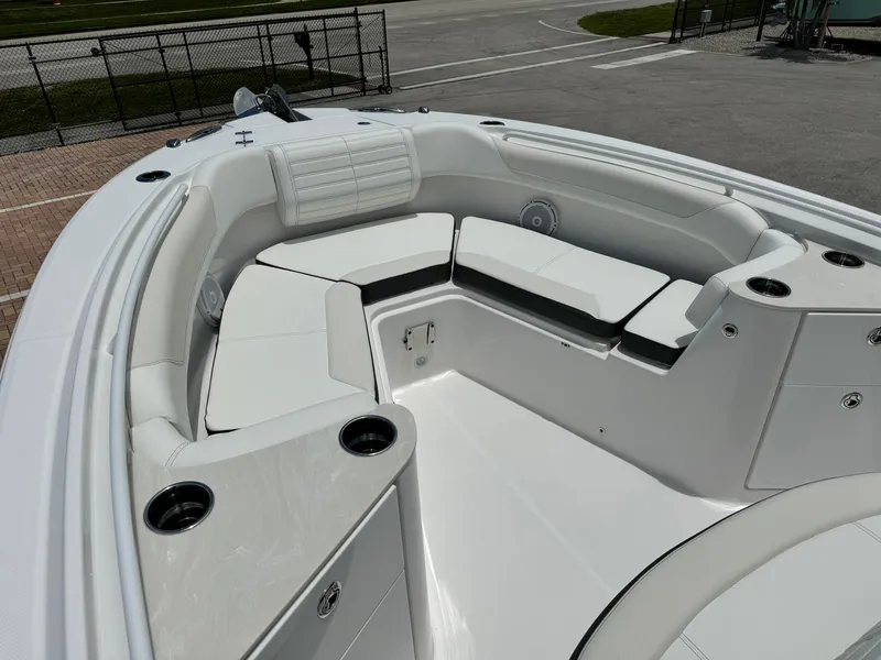 Slide: The Image of 2025 Edgewater 262 CC boat with spacious white seating area and cup holders. - 28