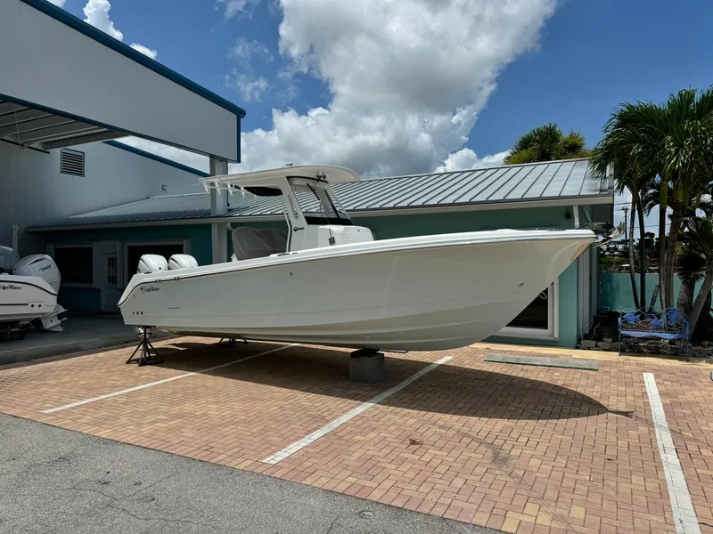 Slide: The Image of 2025 Edgewater 262 CC boat displayed outdoors on a sunny day. - 3