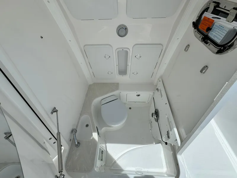 Slide: The Image of 2025 Edgewater 262 CC boat interior with compact marine toilet and sink. - 37
