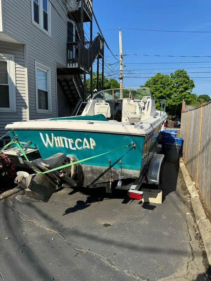 Slide: The Image of 2001 Aquasport 215 Explorer boat parked in driveway, named "Whitecap." - 5