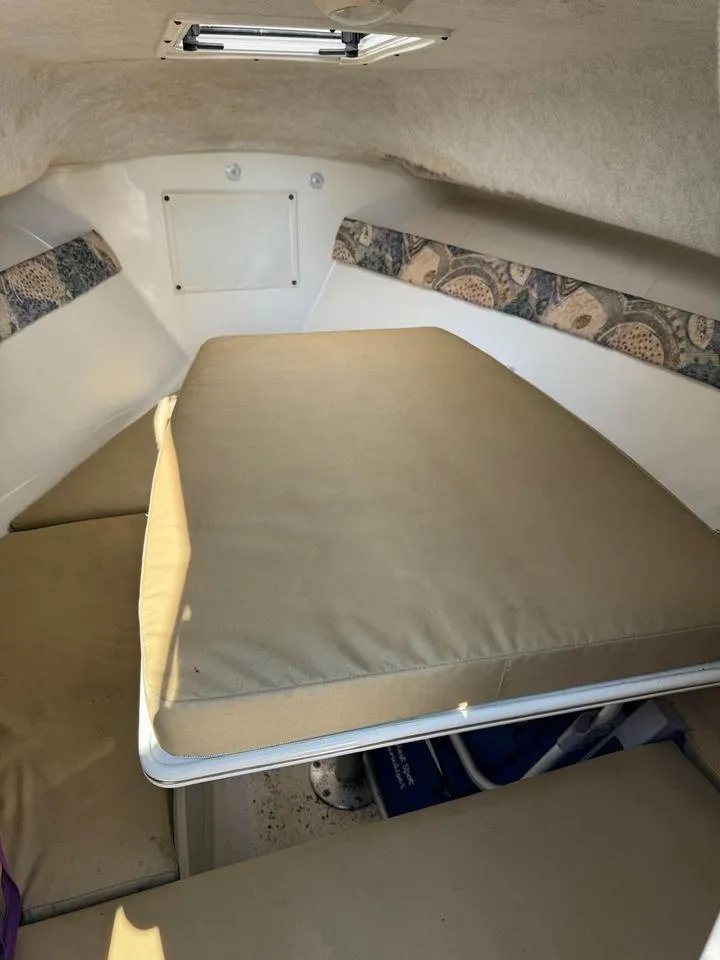 Slide: The Image of 2001 Aquasport 215 Explorer cabin interior with cushioned seating and patterned accents. - 6