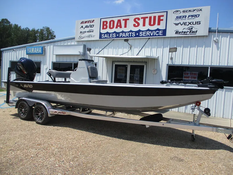 Slide: The Image of Avid 23 Mag 2025 boat on trailer outside dealership, Boat Stuf sign visible. - 1