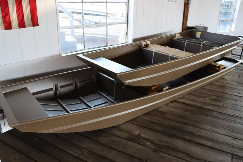 Slide: The Image of 2025 Starcraft 1436 JON TS boat displayed indoors on wooden floor. - 1