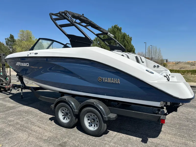Slide: The Image of 2025 Yamaha AR220 boat on trailer, sleek design, blue and white color scheme. - 2