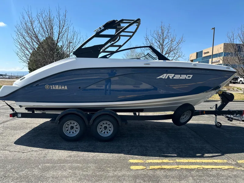 Slide: The Image of 2025 Yamaha AR220 boat on trailer, parked outdoors, side view. - 5