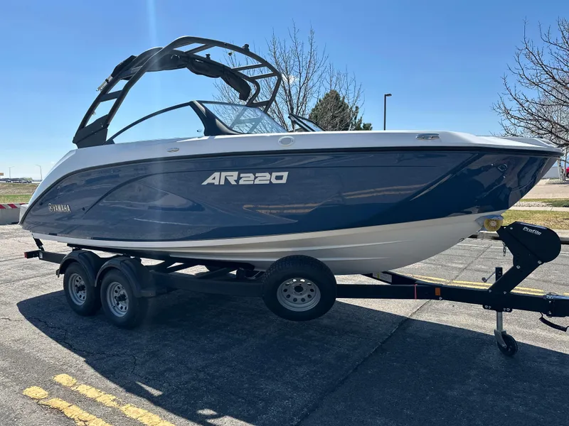 Slide: The Image of 2025 Yamaha Boats AR220 on trailer, parked outdoors under clear blue sky. - 6